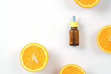 Şişe narenciye uçucu yağ ve beyaz arka plan taze sulu portakal meyve. Cilt için yüksek doz c vitamini sentetik. Düz döşeme, üst görünüm, kopyalama alanı