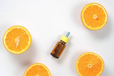 Narenciye uçucu yağ, beyaz arka plan üzerinde taze sulu portakal meyve ile c vitamini serum. Cilt için yüksek doz c vitamini sentetik. Düz döşeme, üst görünüm, kopyalama alanı