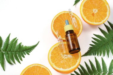 Narenciye uçucu yağ, beyaz arka plan üzerinde taze sulu portakal meyve ve yaprak eğrelti otu ile c vitamini serum. Bitkisel Malzemeler Tonlama ile Organik Spa Kozmetik. Cilt için yüksek doz c vitamini sentetik