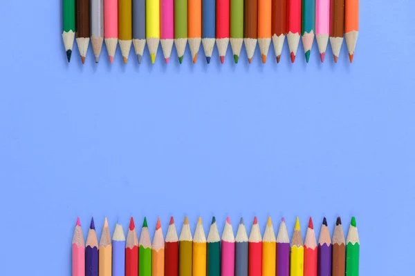 Schulkonzept. kreative Komposition vieler Farbstifte auf violettem Hintergrund. flache Lage, Draufsicht, Kopierraum. — Stockfoto