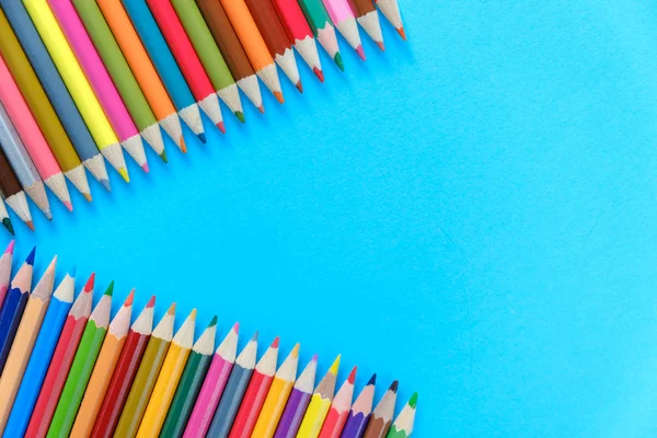 Retour à l'école. Images rapprochées de nombreux crayons de couleur isolés sur fond bleu. Pose plate, vue du dessus, espace de copie . — Photo