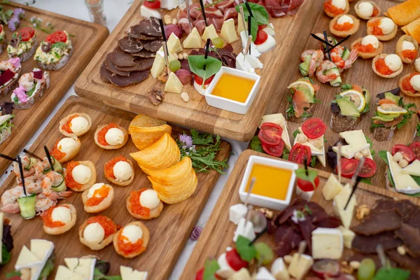 Grande variedade de alimentos com lanches frios, saladas, carnes frias, queijo e geléia servidos. Variedade de deliciosos lanches saborosos na mesa. Recepção de casamento — Fotografia de Stock