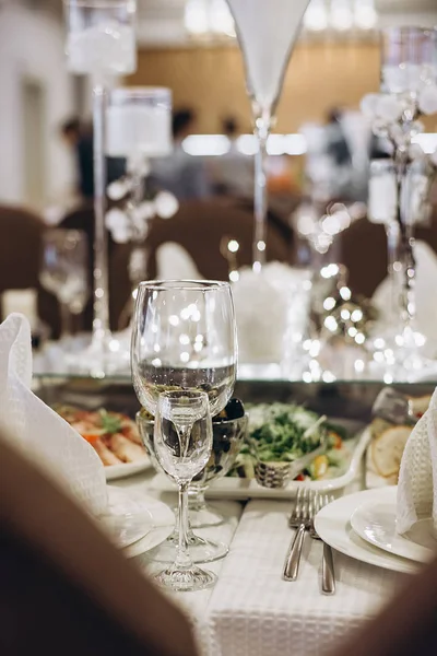 Wine glasses and glasses on the server table.Luxurious elegant dinner at the table in the restaurant. Holiday table decoration