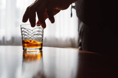 Elinde bir bardak viski olan adamın elini kapatın. Tatma ve degustation kavramı. Bir bardak viskiyle şık takım elbiseli işadamı. Metin için yer