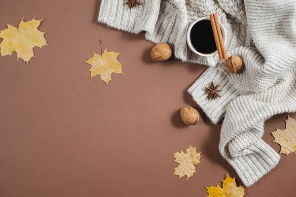 Autumn composition. Cup of coffee, nuts, sweater, autumn maple leaves on brown background. Flat lay, top view, copy space — Stock Photo, Image