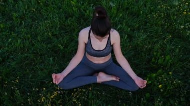 Genç sportif kadın yoga, Ardha Padmasana egzersiz yapıyor, Half Lotus mudra jest ivedu ile poz, egzersiz, spor giyim giyiyor, açık doğa arka plan. Esenlik kavramı