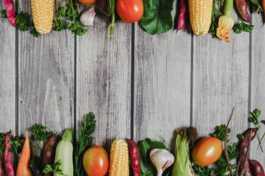 Ahşap arka plan üzerinde çeşitli taze sebzeler. Mısır, domates, kabak, havuç, pancar, sarımsak, fasulye. Gıda konsepti. Düz döşeme, üst görünüm, kopyalama alanı
