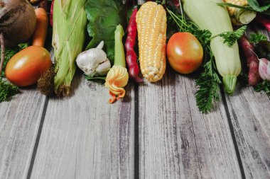 Ahşap arka plan üzerinde çeşitli taze sebzeler. Mısır, domates, kabak, havuç, pancar, sarımsak, fasulye. Gıda konsepti. Düz döşeme, üst görünüm, kopyalama alanı