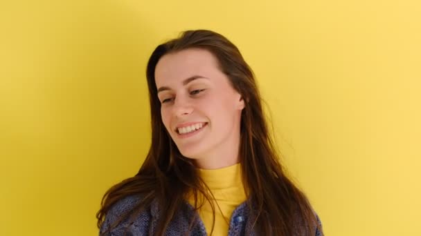 広い笑顔で積極的な若い女性は 黄色の壁に隔離された青いセーターを着ている 人と感情の概念 — ストック動画