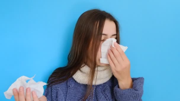生病的女性的肖像有打喷嚏的鼻子 使用手帕 有感染或过敏的东西 穿着随意 隔离在蓝色背景 疾病和疾病概念 — 图库视频影像