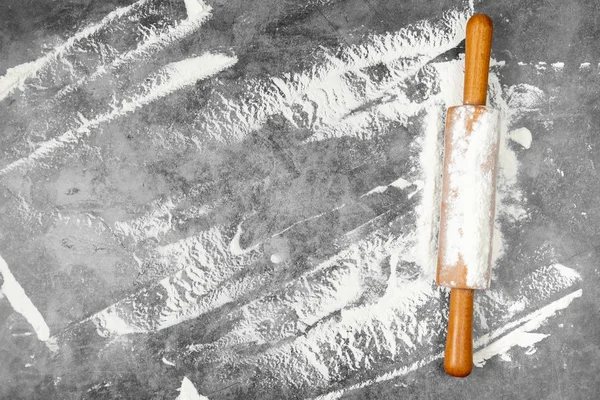 Pişirme düz oklava ile yatıyordu, gri arka plan üzerinde un. Fırında menü, tarifi, ev yapımı pasta konsepti. Metninizin kopya alanı yla üst görünüm.