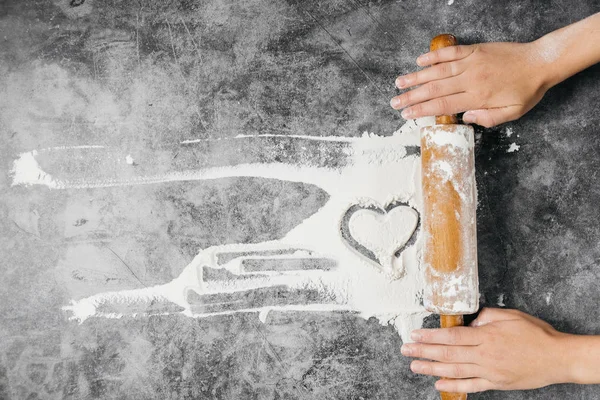 背景を焼く。女の子の手は、コピースペース、トップビューと灰色のテーブルにピンと小麦粉の心臓を転がし続けます。バレンタインデー — ストック写真