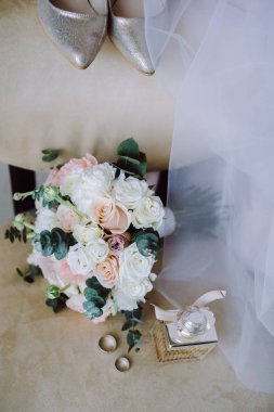 Kırmızı ve beyaz çiçekler güzel modern düğün buketi gül, ayakkabı, bir sandalyede yüzük. Düğün detayları ve doğal bir kavram. Üstte görüntü