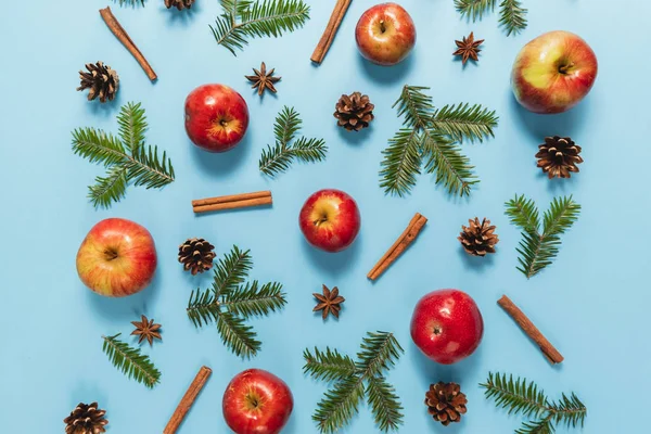 Composição de Natal ou inverno. Quadro feito de ramos de abeto, pinheiro, maçã vermelha e canela no fundo azul pastel. Natal, inverno, conceito de ano novo. Flat lay, vista superior, espaço de cópia — Fotografia de Stock