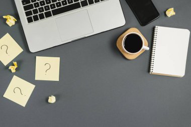 Yapışkan notlardaki soru işareti, defter, fincan kahve, telefon, gri arka plandaki kalem. Faq konsepti. Müşterilerle çalışmak. İşte sorunlar var. Düz konum, üst görünüm, kopyalama alanı
