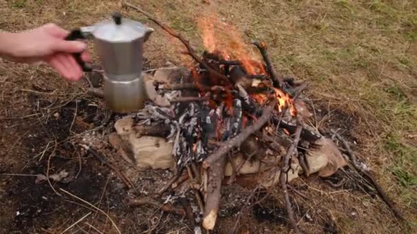 たき火の上でコーヒーを作る女性の手を閉じます コンセプトアドベンチャーアクティブな休暇 美しく刺激的なキャンプの場所と屋外のビブ生活ライフスタイル — ストック動画