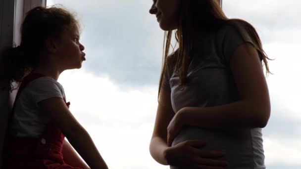 Silueta Cuidar Joven Embarazada Linda Niña Preescolar Sentada Alféizar Ventana — Vídeos de Stock