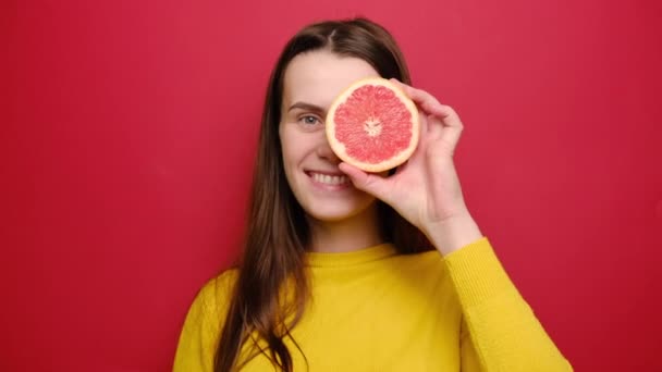 Jovencita Alegre Divertida Haciendo Ojos Con Rodajas Pomelo Jugando Cámara — Vídeo de stock