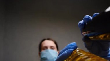 Koruyucu tıbbi maske ve eldiven takan kadın gönüllülerin alt görünüşü yiyeceği kutuya koyar. Coronavirus salgını sırasında evden ve sosyal mesafelere çalışmak için gıda dağıtım hizmetleri. Seçici odak