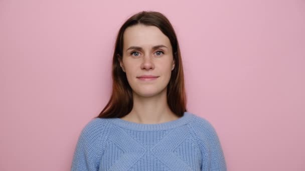 긍정적 귀여운 여성은 괜찮은 몸짓을 스웨터를 인생을 즐기며 스튜디오 위에서 — 비디오