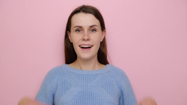 쾌활하고 낙천적 여자가 즐거운 마음으로 손바닥을 스웨터 스튜디오 배경에 고립된 — 비디오