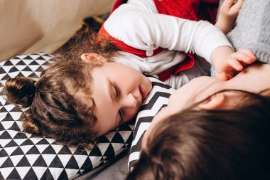 Küçük bir kızın güzel çadırda uzanan mutlu genç anneye sarıldığı, gülümseyen anne ya da dadı dinlenmesi, kızın anneyle olan hassas anının tadını çıkardığı, aşk. Akrabaların aile kavramı