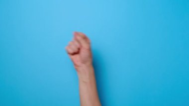 Sayılar hesaplanıyor. 1 'den 5' e kadar parmakları olan, mavi arka planda izole edilmiş ve reklam için fotokopi alanı olan tanınmamış genç bir adama yaklaş. Metin ya da görüntü için yer var. El hareketi