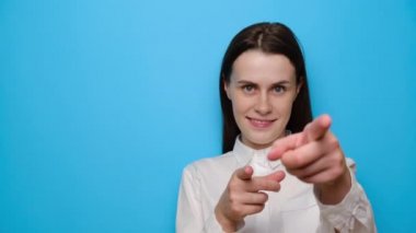 Neşeli kız kameranın gösterdiği çalışma alanı fotokopi şablonu. Mavi stüdyo arka planında izole edilmiş gülümseyen genç bir kadın. Halk yaşam tarzı konsepti