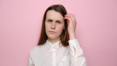 Düşünceli esmer kadın portresi problem çözmeyi düşünüyor. Endişeli genç kız, düşüncelere dalmış, karar vermeyi düşünüyor. Pembe stüdyo arka planında izole edilmiş..