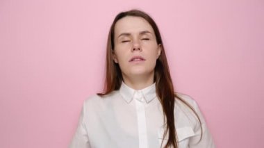 Mudra elleriyle meditasyon yapan odaklanmış bir kadının portresi, sakin genç kız yoga yapıyor gözleri kapalı, duyguları kontrol ediyor, derin nefes alıyor, pembe stüdyo arka planında izole edilmiş. Stressiz konsept