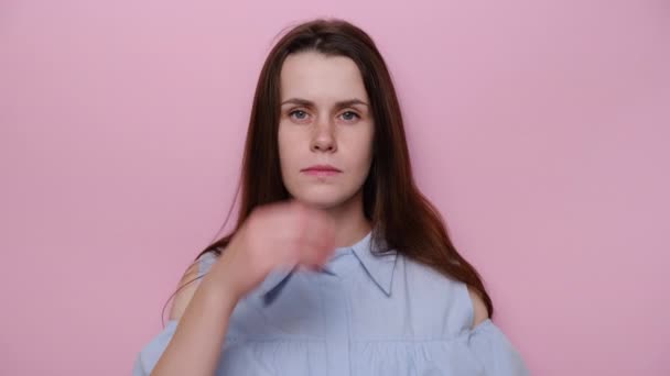 真剣な若い女性の肖像画は何かについて考えて ブルーのシャツに身を包んだ ピンクのスタジオの背景に孤立立って ブルネットの女の子のアイデアを夢見て 疑義と混乱の概念 — ストック動画