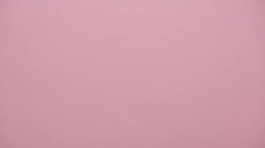 Fotokopi odası olan pembe stüdyo arka planında izole edilmiş, yumruk sallayan, tanınmayan kızgın bir kadının yakınına. Reklam alanı, modelle. Tehdit jesti, saldırganlık kavramı, uyarı, ceza