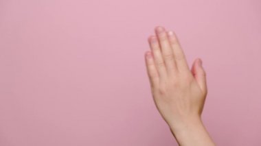 Tanınmayan bir kadının el ele tutuşup Tanrı 'ya dua etmesi, meditasyon yapması, sağlık, farkındalık ve başarı için dua etmesi, fotokopi çekilen pembe stüdyo arka planında izole edilmiş. Din kavramı.