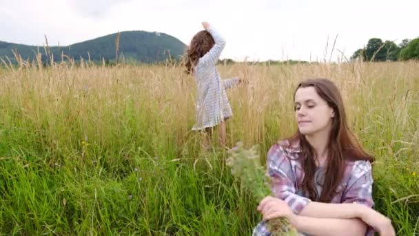 Молода Красива Мати Сидить Траві Нюхає Букет Диких Квітів Поруч — стокове відео