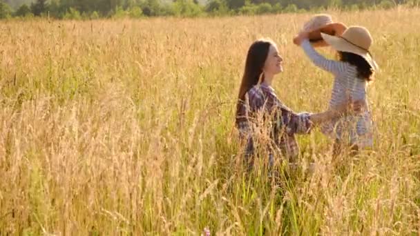 자연의 잔디에 모자를 귀여운 아이와 엄마를 어머니와 여름내 야외에서 시간을 — 비디오