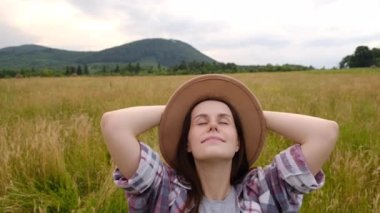 Yürüyüş yapan genç bir kadının el ele tutuşup sakin bir yaz gününün tadını çıkardığı, temiz hava soluyan, rüzgarda savrulan saçlar. Huzurlu kadın meditasyonu, rahatlama egzersizleri, hafta sonunun tadını çıkarmak.