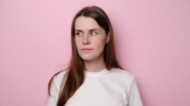 Endişeli esmer genç kadının portresi sessiz kalmak istiyor, gizemi korumak için dudaklarını tutuyor, pozitif kız gizli bilgileri anlatmıyor, pembe stüdyo arka planında izole edilmiş.