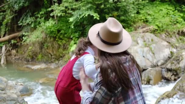 Amante Madre Joven Besa Linda Hija Pequeña Pie Cerca Cascada — Vídeos de Stock