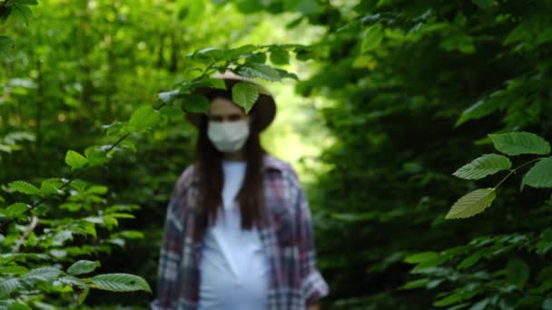 身披医学无菌面罩的年轻孕妇形象漫步森林 摘下防护面罩微笑深呼吸深深感受幸福与健康 检疫结束 Covid 19失败的概念 — 图库视频影像