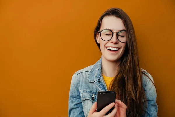 Sonriendo Mujer Joven Feliz Gafas Sostiene Teléfono Inteligente Sonríe Positivamente —  Fotos de Stock
