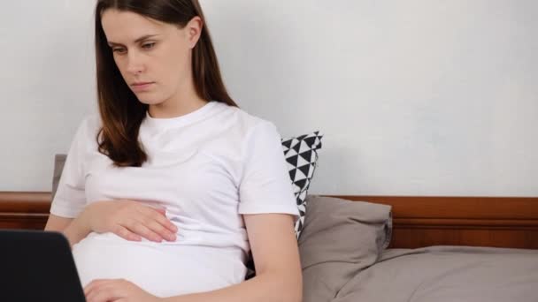 Femme Enceinte Concentrée Couchée Sur Lit Confortable Travaille Sur Ordinateur — Video