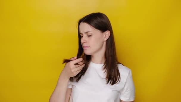 Smutná Mladá Žena Hledící Rozštěpené Konce Izolovaná Žlutém Pozadí Studia — Stock video