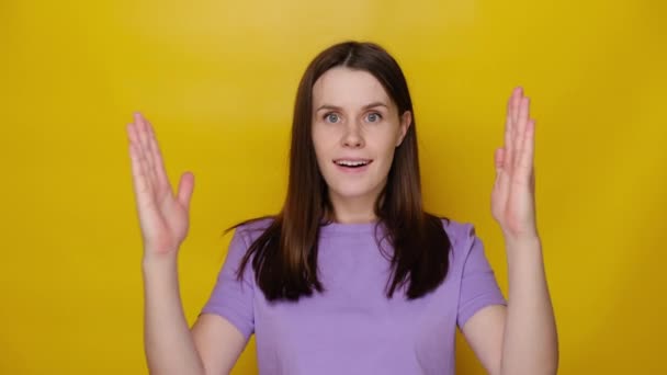 Έκπληκτη Νεαρή Γυναίκα Απομονωμένη Στο Κίτρινο Φόντο Στούντιο Δείχνει Μεγάλο — Αρχείο Βίντεο