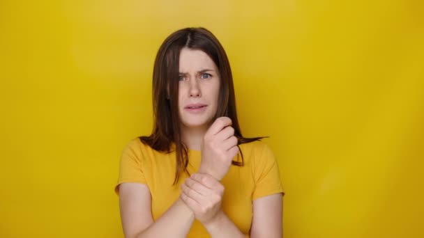 건강하지 여성이 스러운 손으로 마사지를 티셔츠를 노란색 스튜디오 배경에 스러워 — 비디오