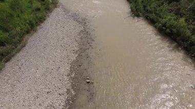 Yaz günü şiddetli yağmurdan sonra hızla akan azgın nehrin hava aracı görüntüsü. Çevresel hasar.