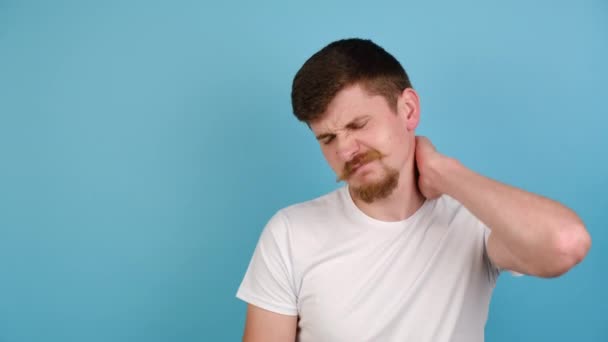 Unhappy Young Man Isolated Blue Studio Background Massaging Hurt Stiff — Stock Video