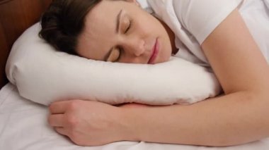 Sabahları yavaşça uyandıktan sonra yatakta uzanan ve esneyen çekici genç bir kadın. Mutlu kız yeni günü selamlıyor. Taze tembel kadın evde sağlıklı bir uykudan sonra uyanıyor. Seçici odak