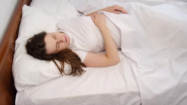침대에 임산부는 불면증이나 시끄러운 이웃에 고통받고 담요로 문제를 걱정하며 걱정하며 — 비디오