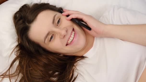 Gülümseyen Milenyum Kadınlarının Yakın Çekimde Rahat Beyaz Bir Yatakta Uzanmış — Stok video