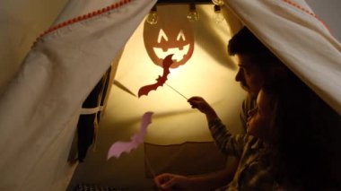 Sevgi dolu bir baba, küçük kızını çadırda otururken eğlendirir. Haftasonunu evde kağıt yarasalarla oynar. Heyecanlı küçük kız gölgeler tiyatrosunu izlemekten zevk alır. Mutlu Cadılar Bayramı konsepti